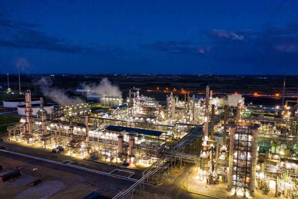 Refinaria iluminada ao anoitecer